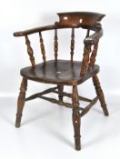 A Victorian oak smokers bow chair, spindle back with tapered turned supports,