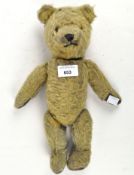 A vintage jointed mohair teddy bear with brown pads, black stitched nose and orange eyes,