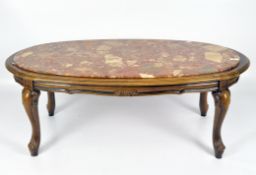 A 20th century marble top coffee table, of oval form, raised upon carved cabriole legs,