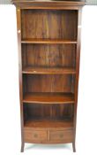 A contemporary hardwood open bookcase, bow fronted, three shelves above two small drawers,