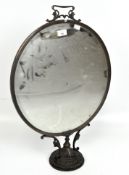 A Victorian fire screen, with central oval mirror within a bronze frame