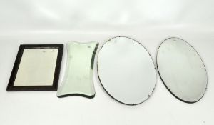 A group of four wall mirrors, comprising one stained oak example and three bevelled edge,