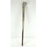 An Indian white metal tiger's headed cane, cast and incised with leaves, within gilt bands,