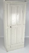 A 20th century white painted single door wardrobe, opening to reveal fitted interior,