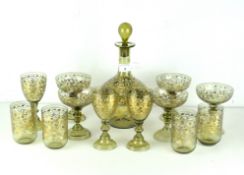 An ornate green glass decanter set, inlaid with flowing gilt floral sprays.