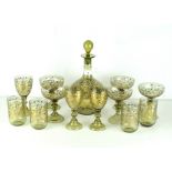 An ornate green glass decanter set, inlaid with flowing gilt floral sprays.