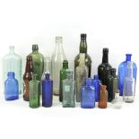 A collection of vintage glass bottles, blue, red, green and white glass examples,