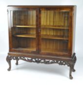 A mahogany display cabinet of rectangular form with acanthus edge carved top