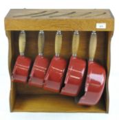 A five piece red cast iron Cousances saucepan set, of graduating form,