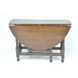 An early 20th century oak oval gate leg table on turned and squared supports,