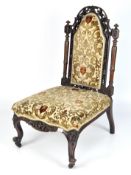 A Victorian nursing chair, the wooden frame carved with vines and motifs,