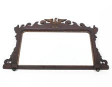A Georgian style mahogany and parcel-gilt mirror, carved with a gilt eagle within scrolled frame,