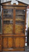 A mahogany veneer bookcase with dental broken pediment top with fancy astragal glazed doors,