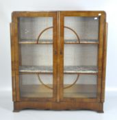 An Art Deco glazed display cabinet with two shelves behind double doors with lock and key,