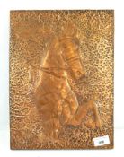 A 20th century hammered copper plaque depicting a horse,