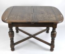 An oak extending dining table, with two leaves, on turned supports,