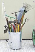 A large collection of gardening and work tools, including saws and spades,