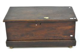 A late 19th century elm blanket box, with hinged lid, later modified with bun feet,