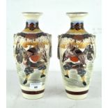 A pair of early 20th century Japanese ceramic vases, each decorated with Samurai and floral motifs,