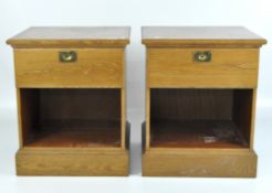 A pair of blonde oak bedside cabinets, each with a single drawer over an open shelf,