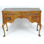 A early 20th Century serpentine kneehole desk, two longer drawers above two smaller ones,