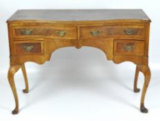 A early 20th Century serpentine kneehole desk, two longer drawers above two smaller ones,