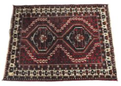 A Turkish dark red ground carpet with orange and beige details,