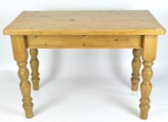 A pine kitchen dining table on turned baluster legs,