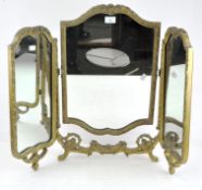 A gilt wood and gesso three part dressing table mirror with floral moulded frame, on scroll feet,