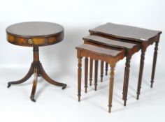 A trio nest of mahogany tables with a drum side table