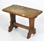 A small mid-century oak coffee table or stool, raised on splayed support,