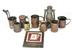 A collection of copper and brassware, including a group of tankards and three graduated measures,