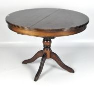 A contemporary mahogany veneer dining table of circular form,