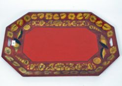 A large red painted butlers tray, twin handled, decorated with gilt floral and shell detailing,