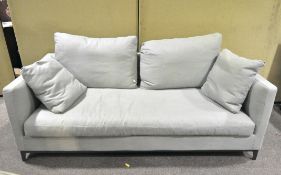 A large pale blue linen sofa and cushions,