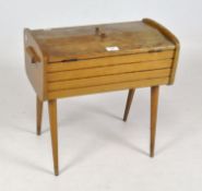 A vintage wooden sewing box, raised upon tapering supports,