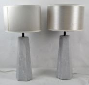 A modern pair of mottled white stone hexagon lamp stands with cream shades,