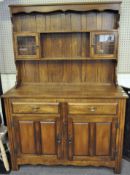 A 20th century oak dresser, the three tier top with two small glazed doors,