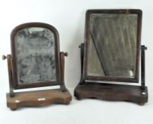 Two Victorian mahogany dressing table mirrors, both raised on bun feet,