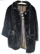 A ladies vintage faux fur coat, black with two pockets and brown fabric lining,