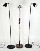 Three modern standard lamps, two matt black, one of chrome and wood,