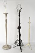 A wrought iron standard lamp, with flowing scrolling motifs,