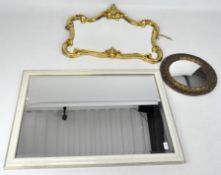 Three wall mirrors, two contemporary examples, one with a white frame and bevelled edge,