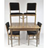 A Gordon Russell oak table and four chairs, the chairs with upholstered seat and back,