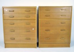 Two mid-century four drawer light oak chests, raised on plinth bases,