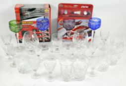 A collection of assorted glassware, including coloured cut glass wine glasses, aperatif glasses,
