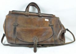 A large vintage leather travel bag, with pocket and shoulder strap,