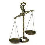 A set of brass weighing scales with moulded relief decoration,