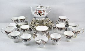 A Colclough part tea set with a brown and black floral pattern on a white ground with gilt trim