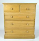 A modern pine chest of five drawers with turned knobs,